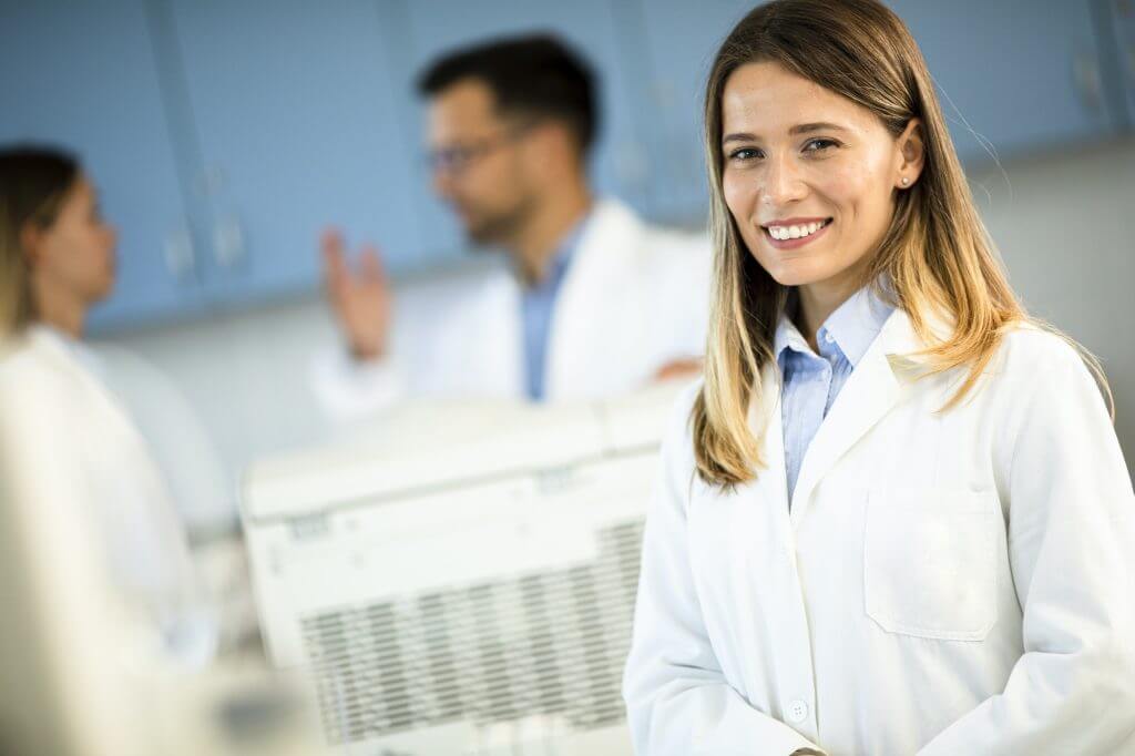 Female scientist in white lab coat standing in the biomedical lab