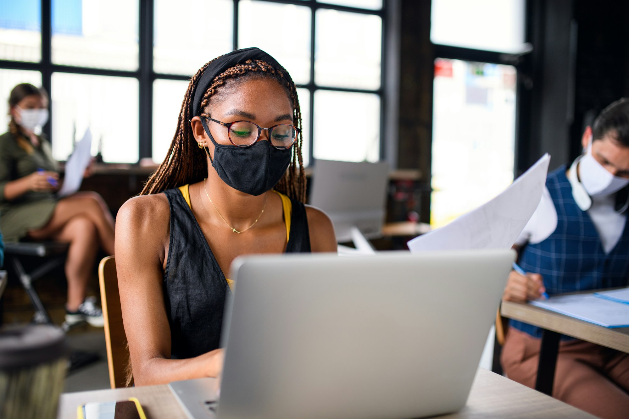 Business people with face masks indoors in office, back to work after coronavirus lockdown