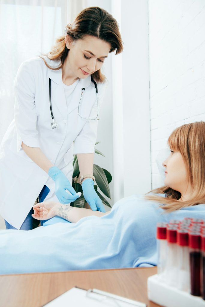 doctor preparing donor for blood donation in hospital