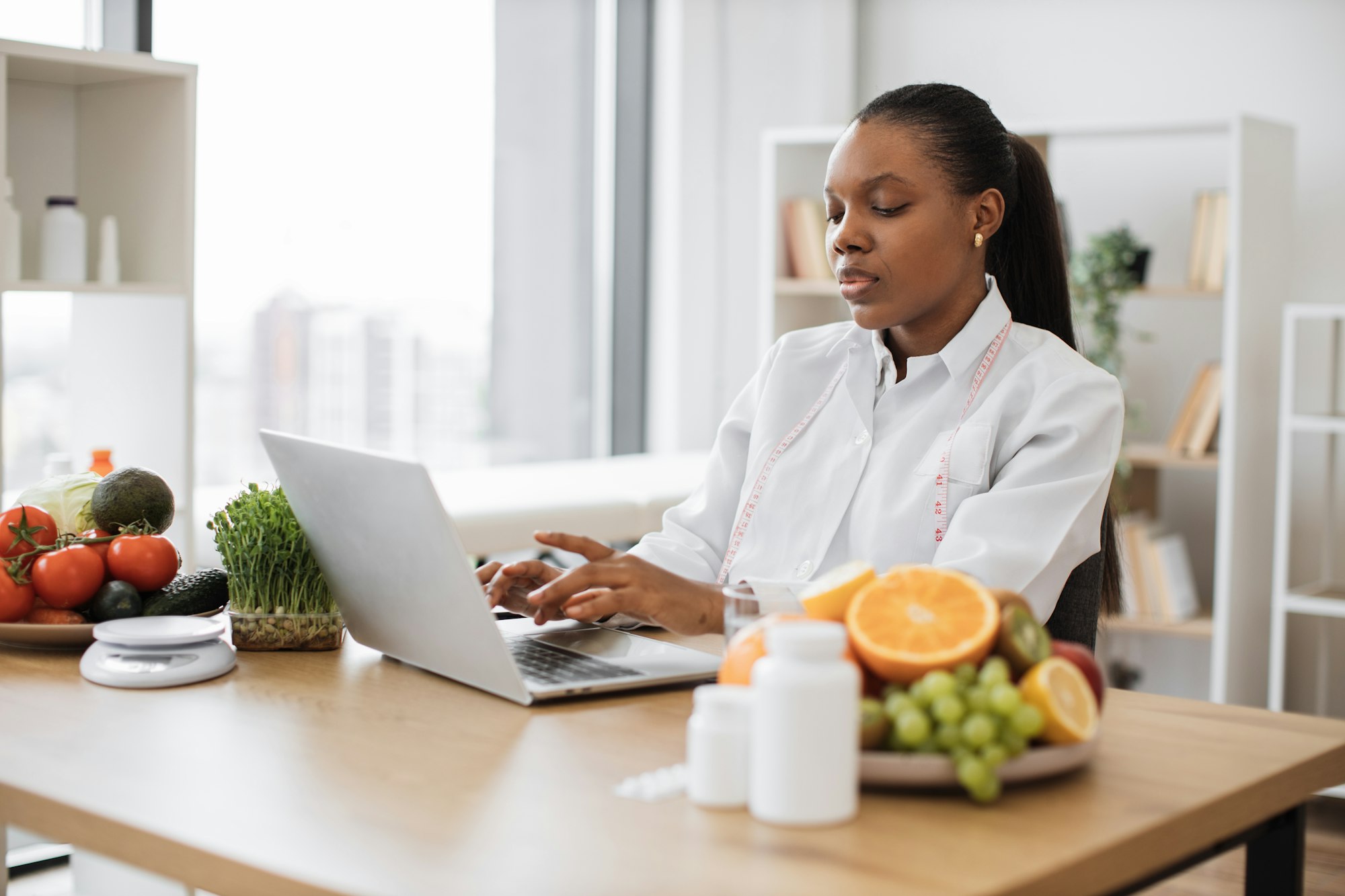 Food expert typing on laptop in consulting room of clinic