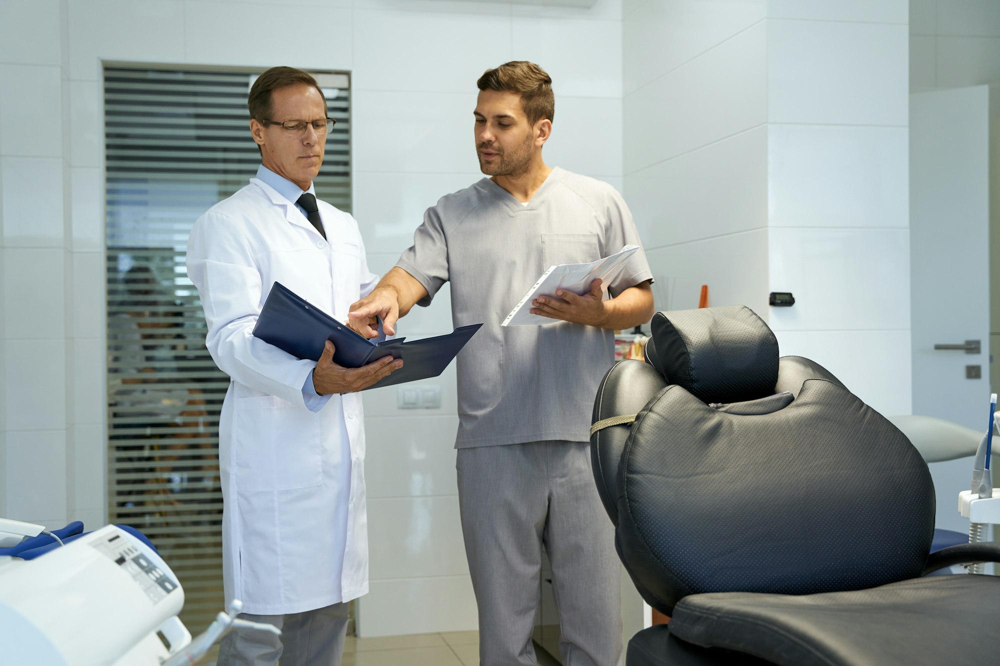 Two medical workers looking at papers in dental clinic