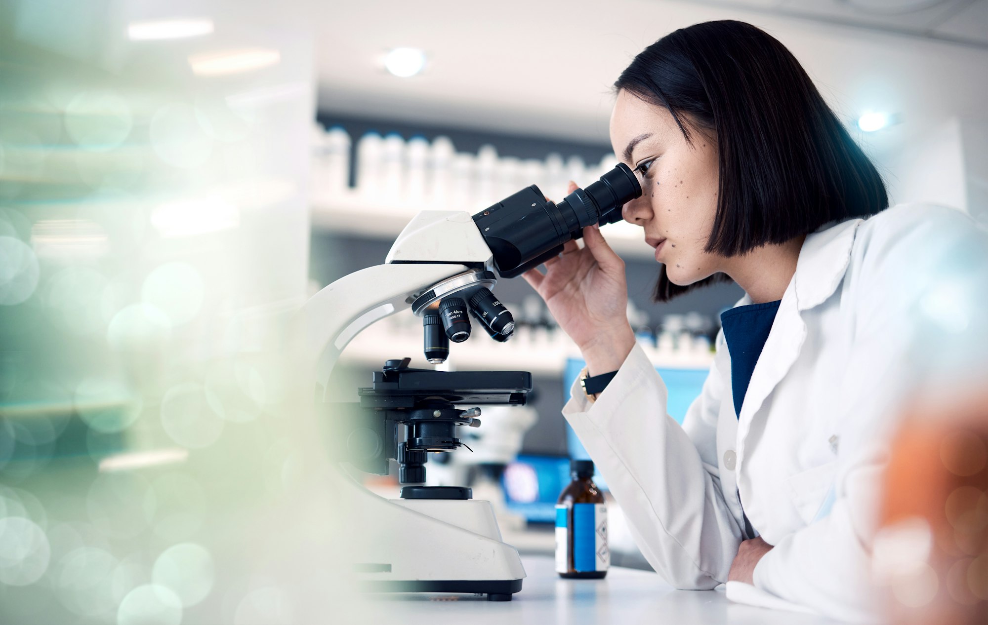 Woman, laboratory or doctor with microscope for science data analysis, medical innovation or health